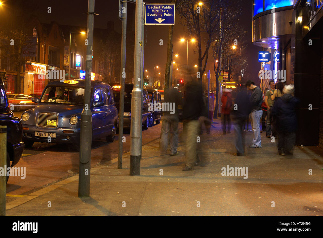 people nightclubbers walking past pubs and clubs on bradbury place belfast at taxi rank Stock Photo