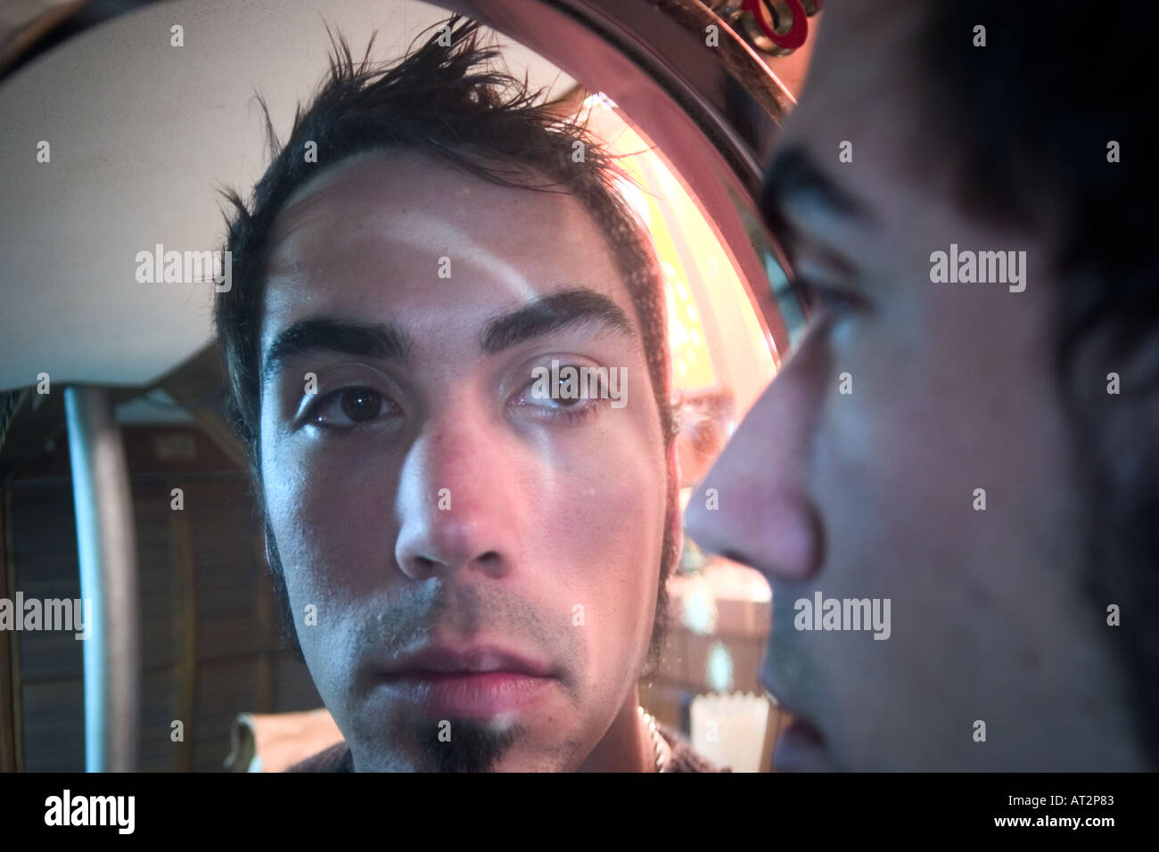 Man looking into a mirror that distorts his face Stock Photo Alamy