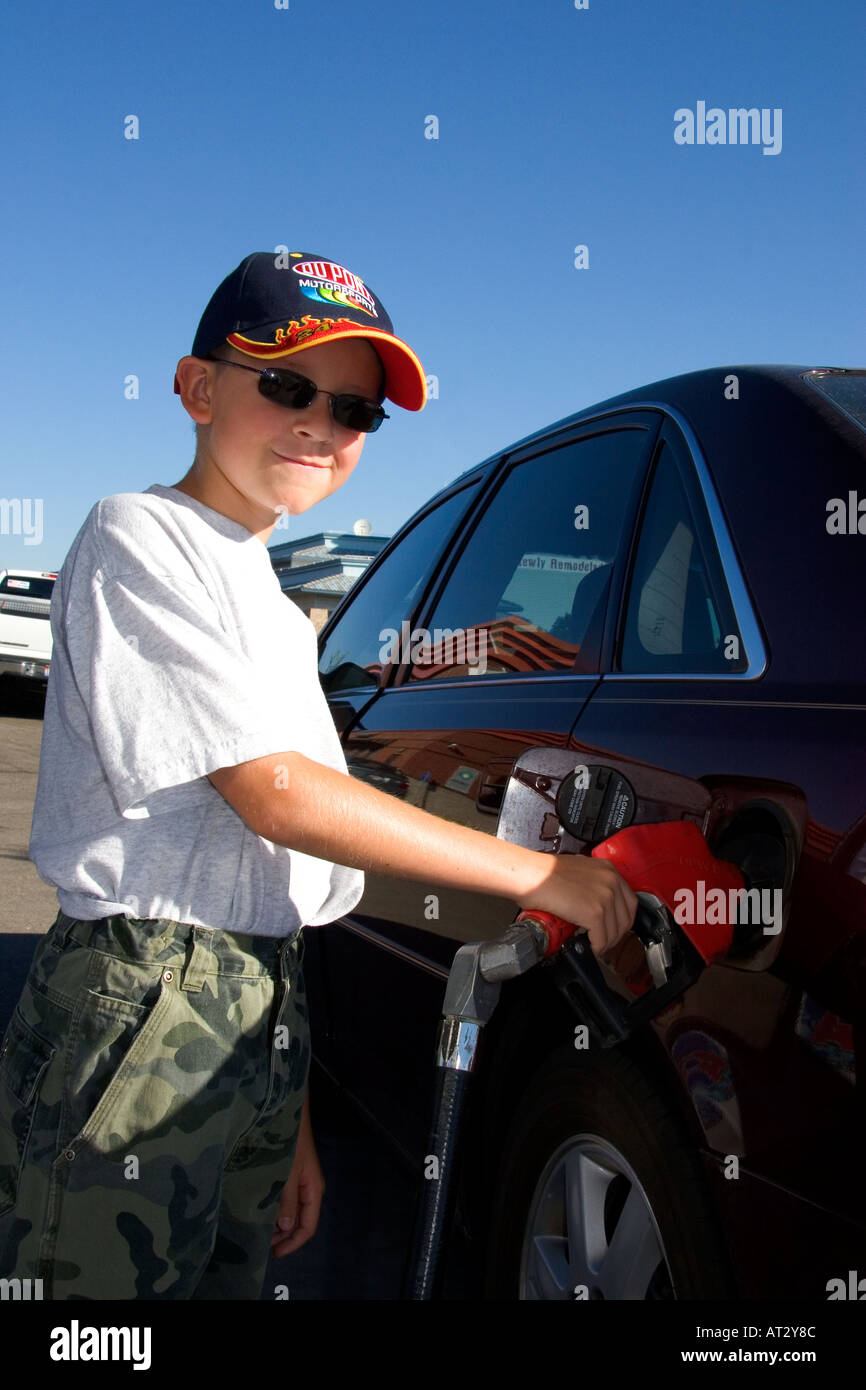 A nine year old boy pumps gasoline into a car at a gas station in Boise ...