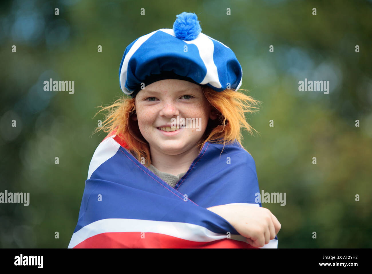 a young boy with a funny hat with Scottish colours and red hair Stock Photo