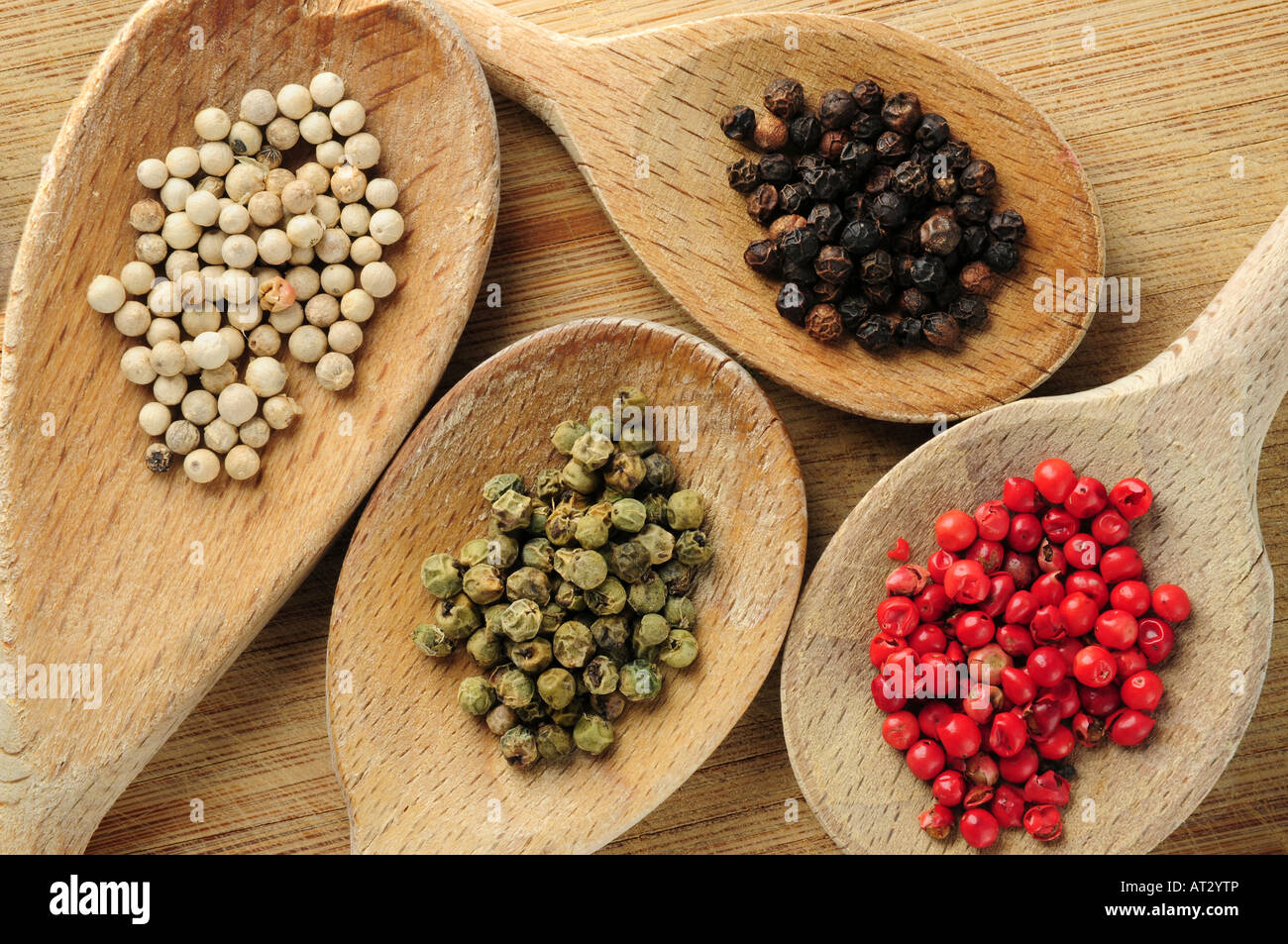 Four kinds of peppercorns in wooden cooking spoons Stock Photo Alamy