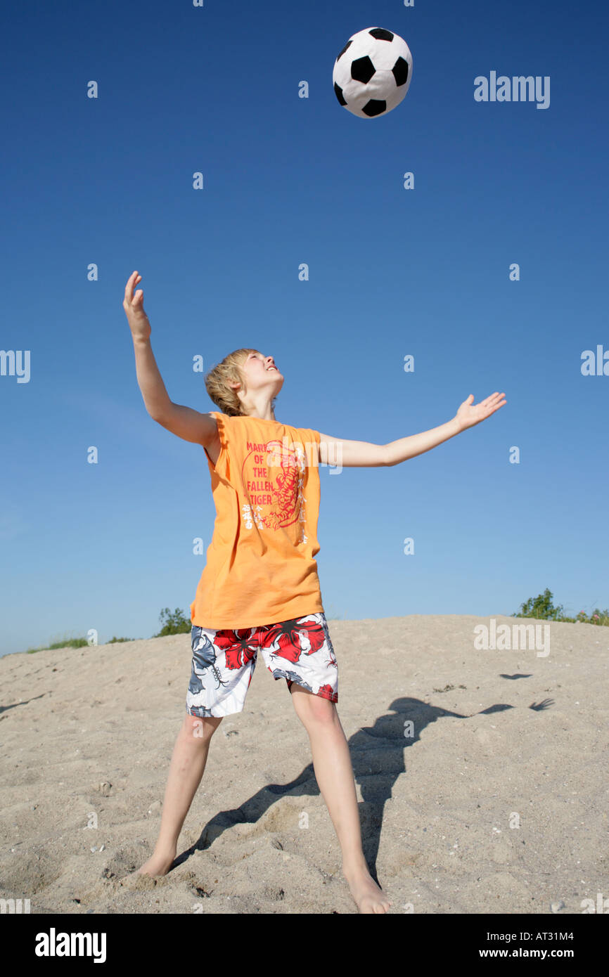 a young boy throwing a ball up in the air Stock Photo Alamy