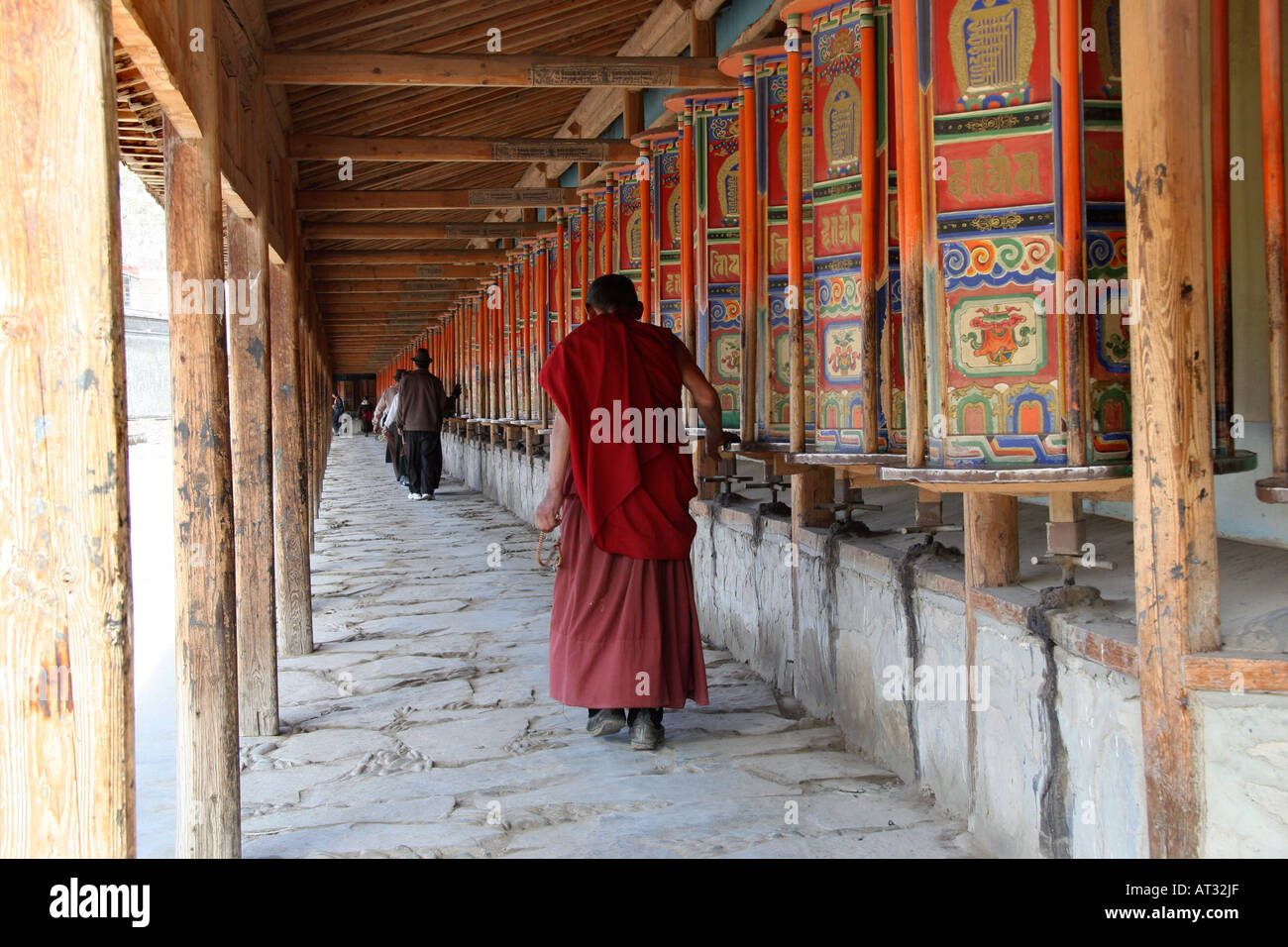 Monk spinning prayer wheels on the pilgrim circuit at the famed Labrang Buddhist Monastery, Xiahe, China Stock Photo