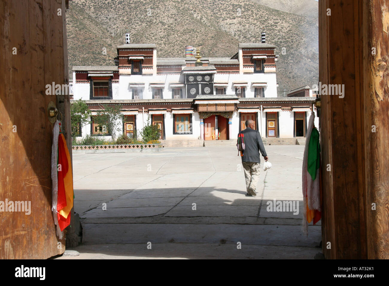 Pilgrim entering the gates off the pilgrim circuit at the famed Labrang Buddhist Monastery, Xiahe, China Stock Photo