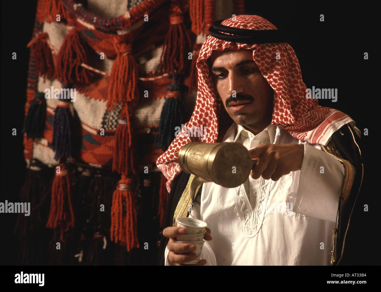 Jordanian man pours traditional cup of Arabic Coffee in Jordan Stock