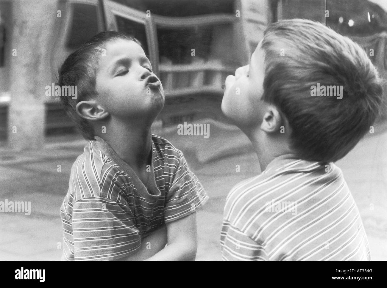 A boy making faces in a mirror Stock Photo