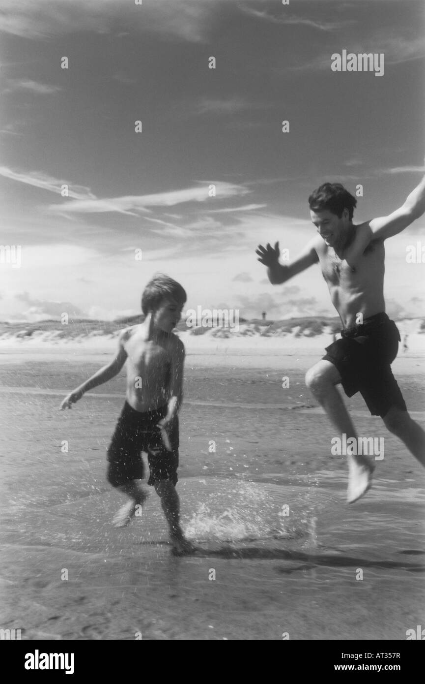 A father and son splashing around in the sea together Stock Photo - Alamy