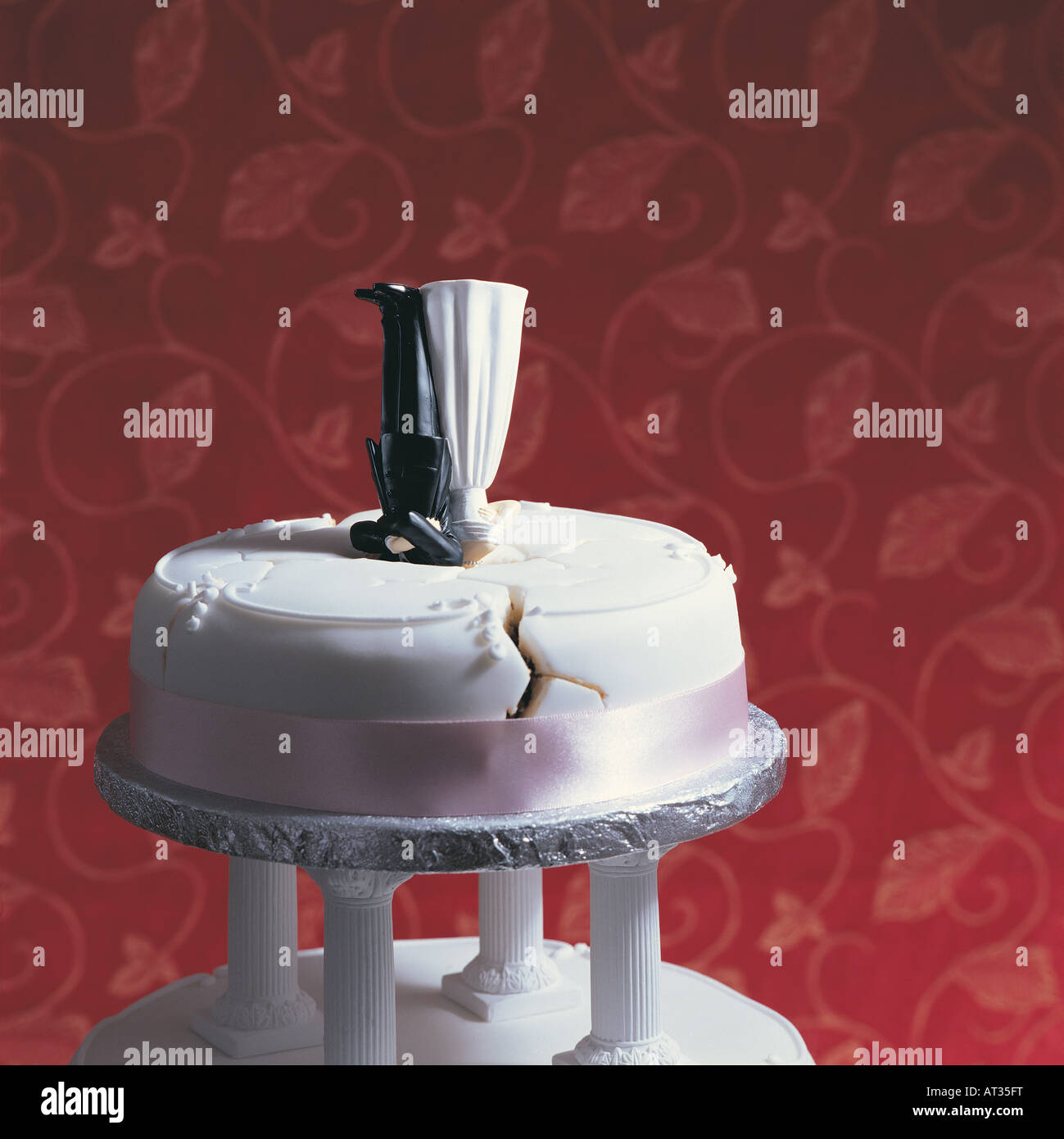 A Wedding cake, bride and groom upside down, cracked icing Stock Photo