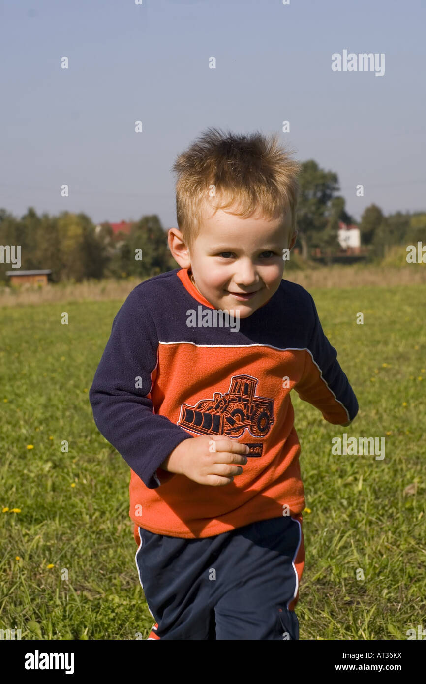 Boy (6-7) running on field Stock Photo