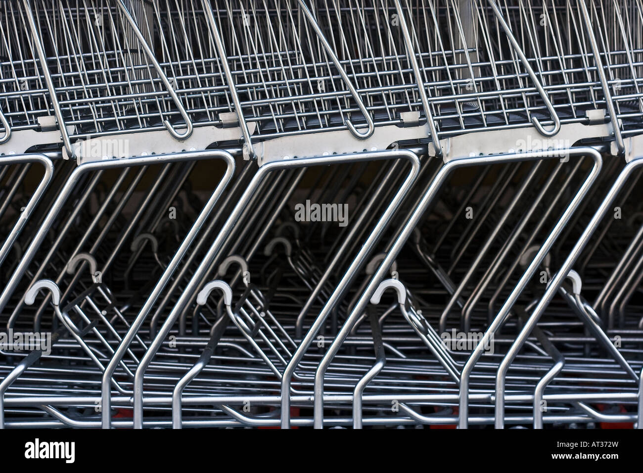 A detailed view of shopping carts stacked in a row outside a supermarket Stock Photo