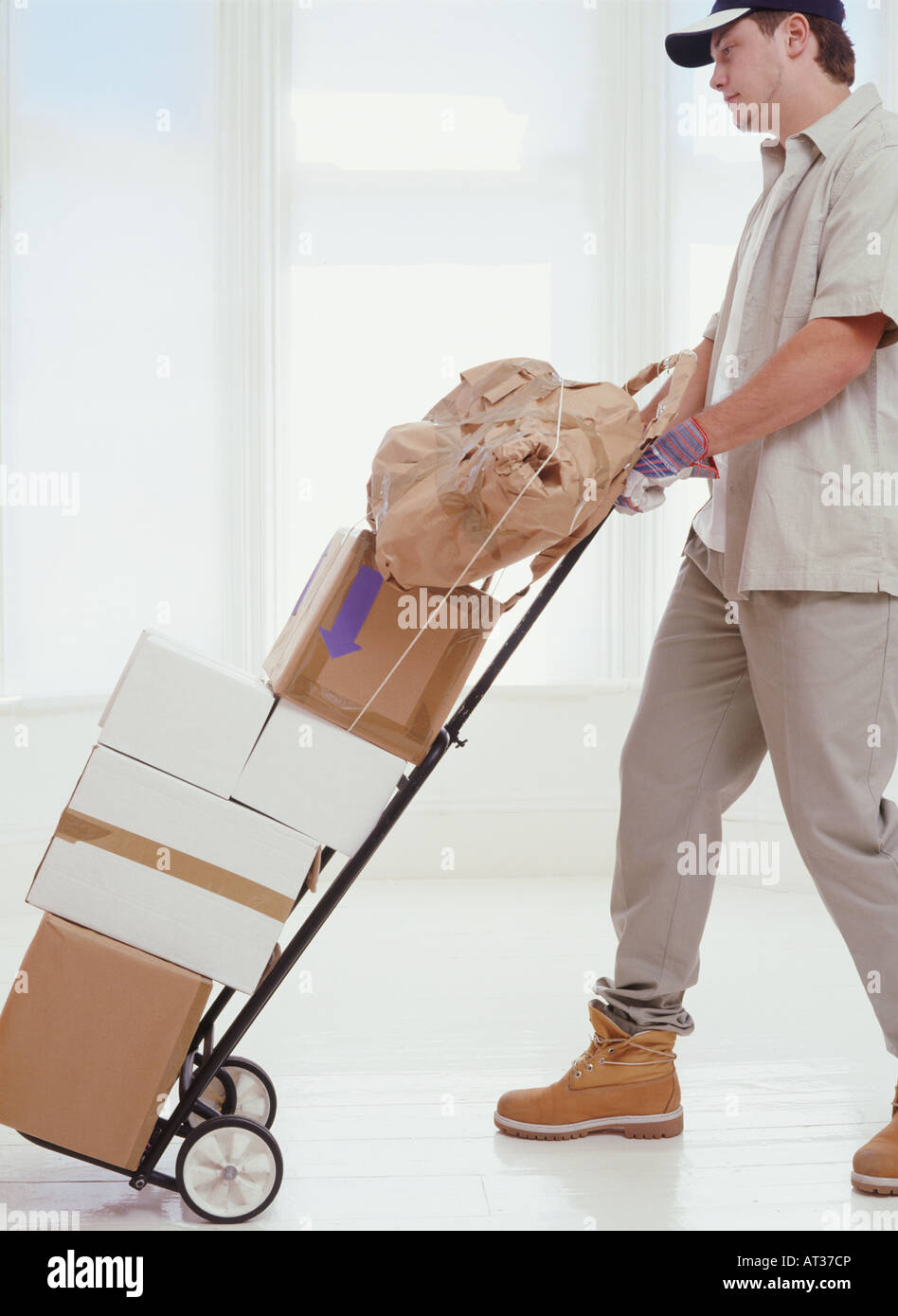 A delivery man pushing a trolley with parcels on it Stock Photo Alamy