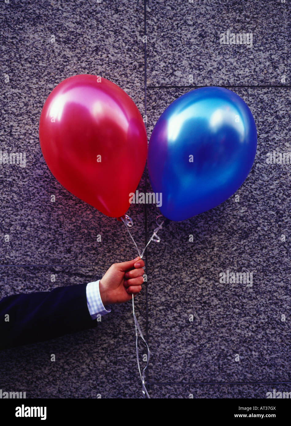 A man holding red and blue balloons Stock Photo