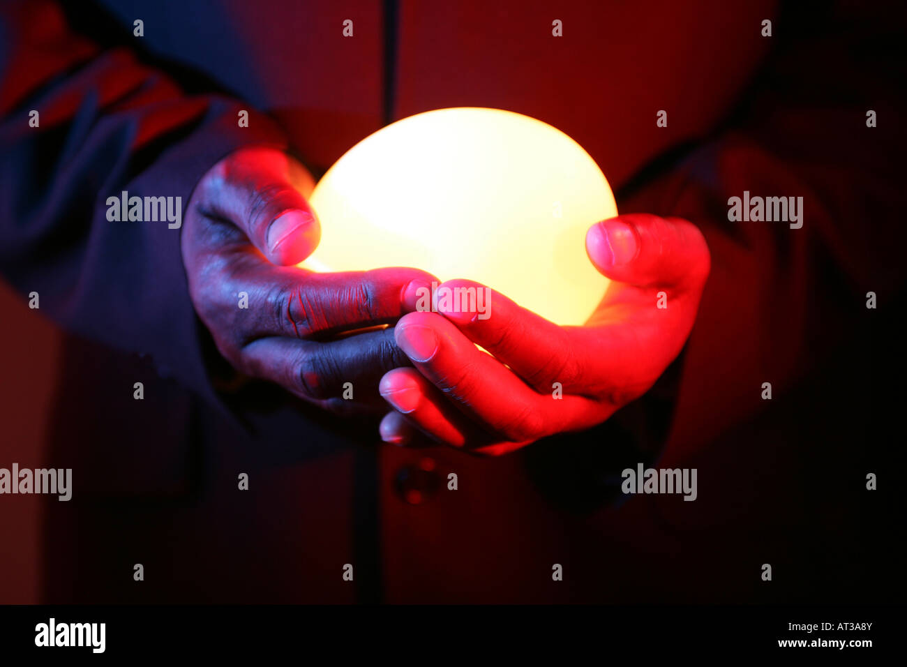A man holding an oval light in both hands Stock Photo