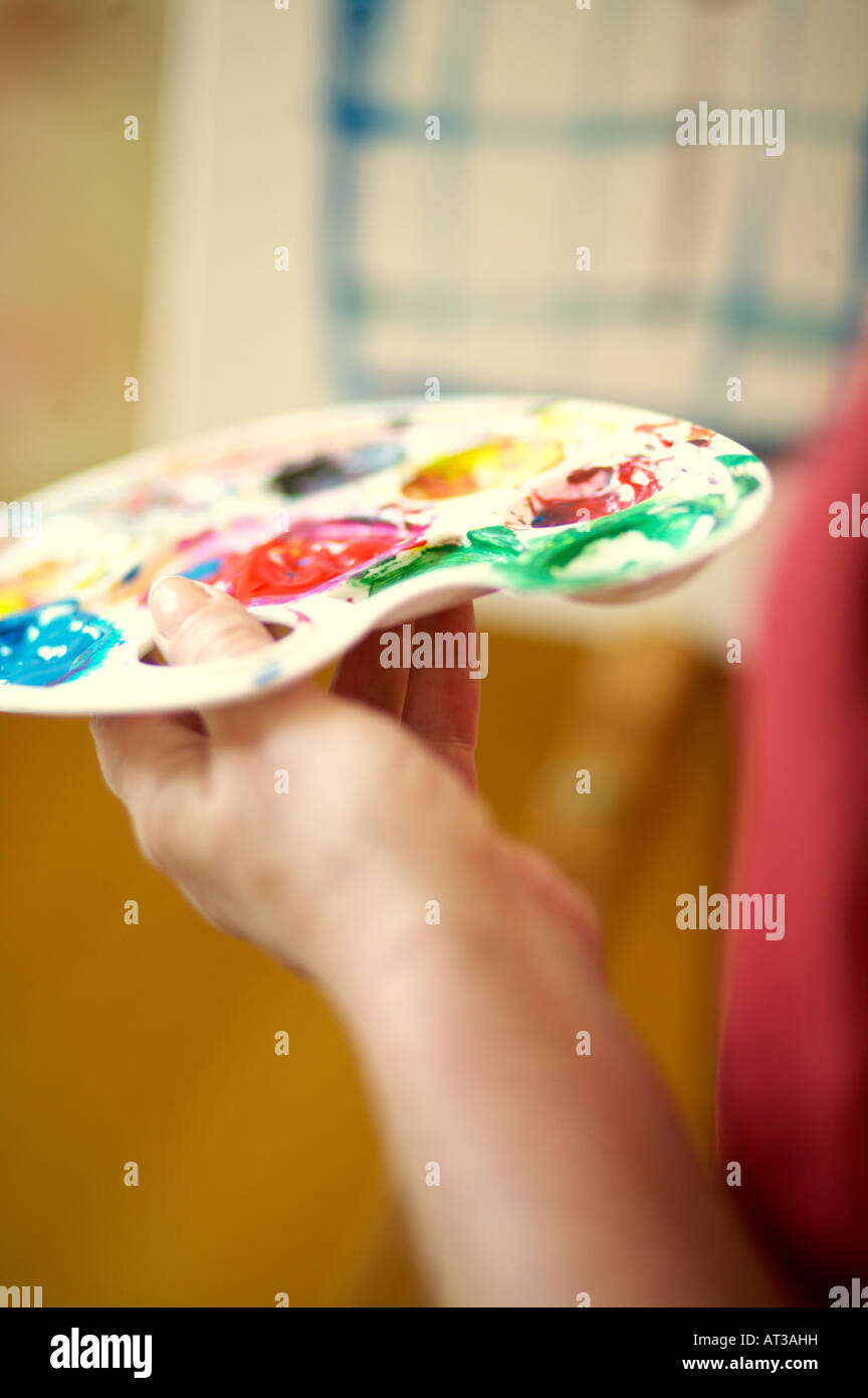 A female artist holding a paint palette, close-up Stock Photo