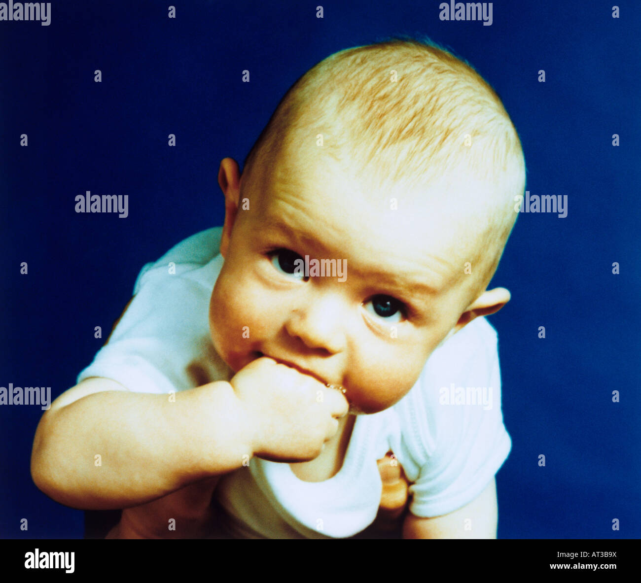 A baby with its hand in its mouth, teething Stock Photo Alamy