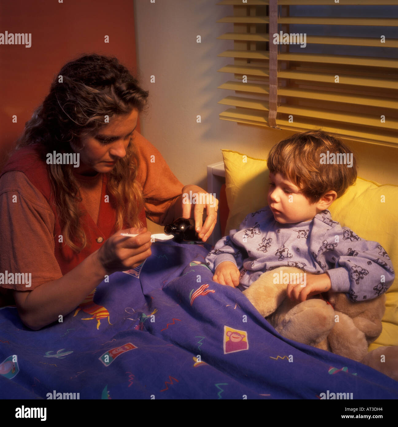 Mother gives a child a cough mixture Stock Photo Alamy