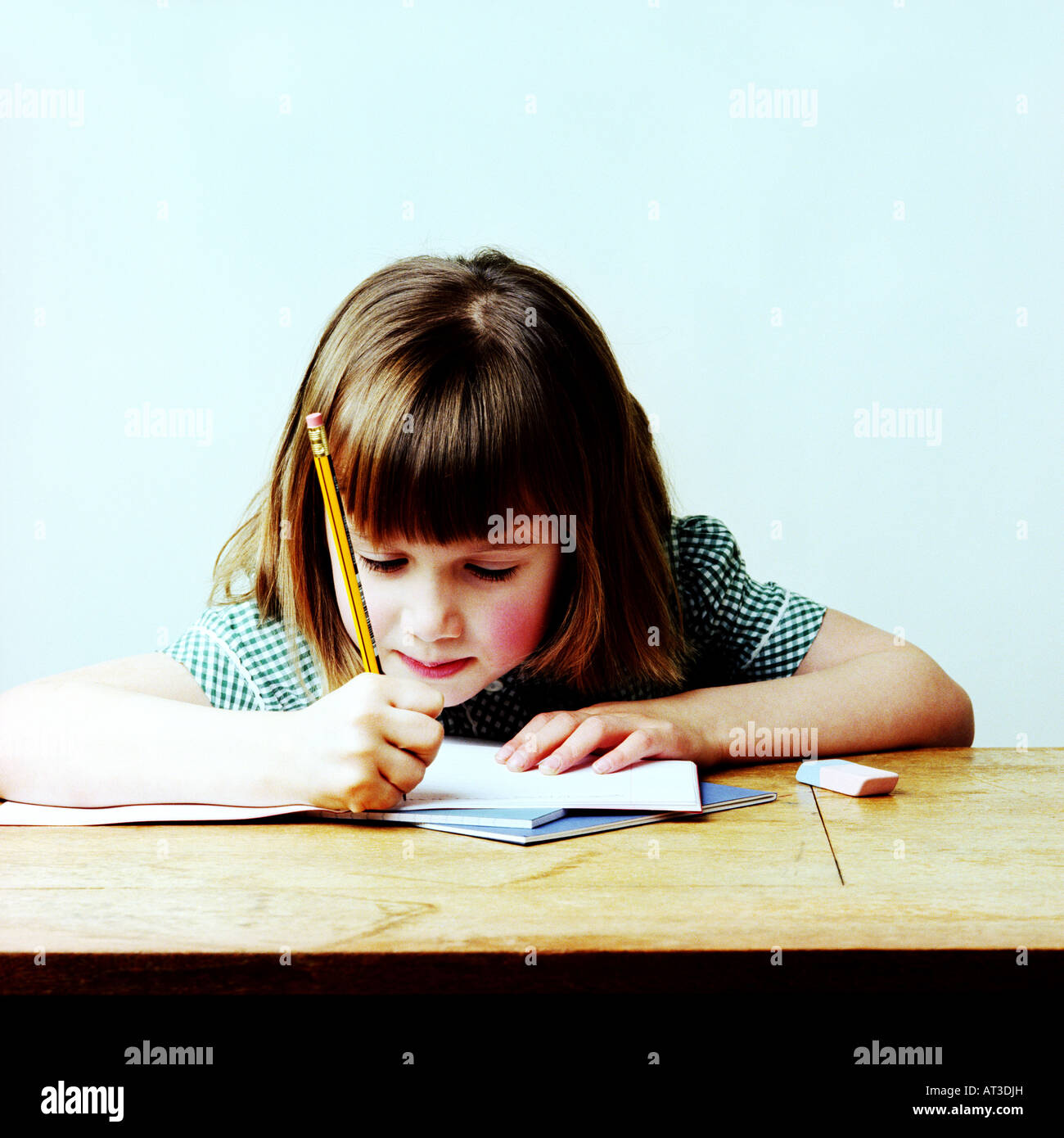 A school girl sitting at a desk working Stock Photo - Alamy
