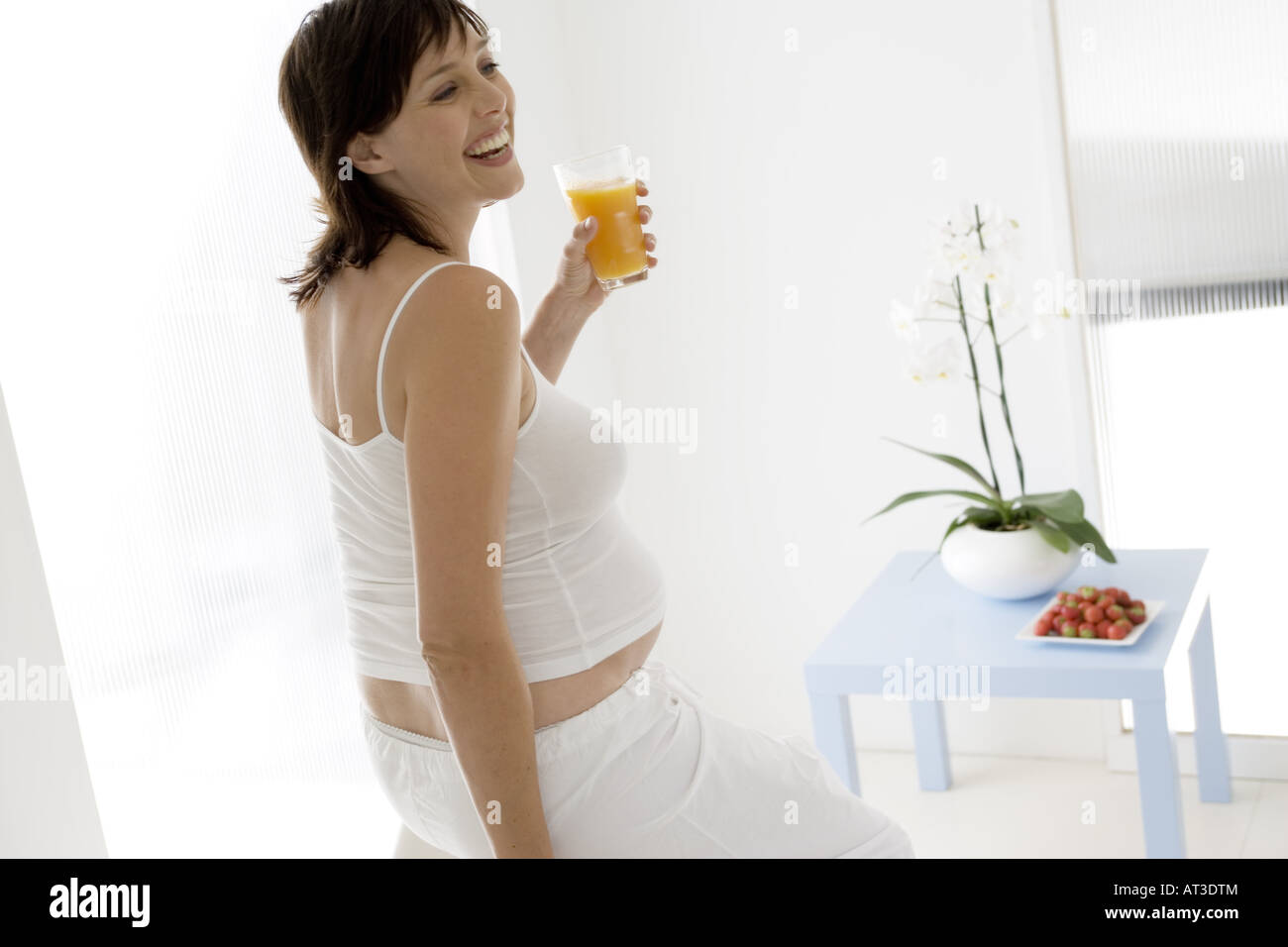 A pregnant woman drinking orange juice Stock Photo Alamy