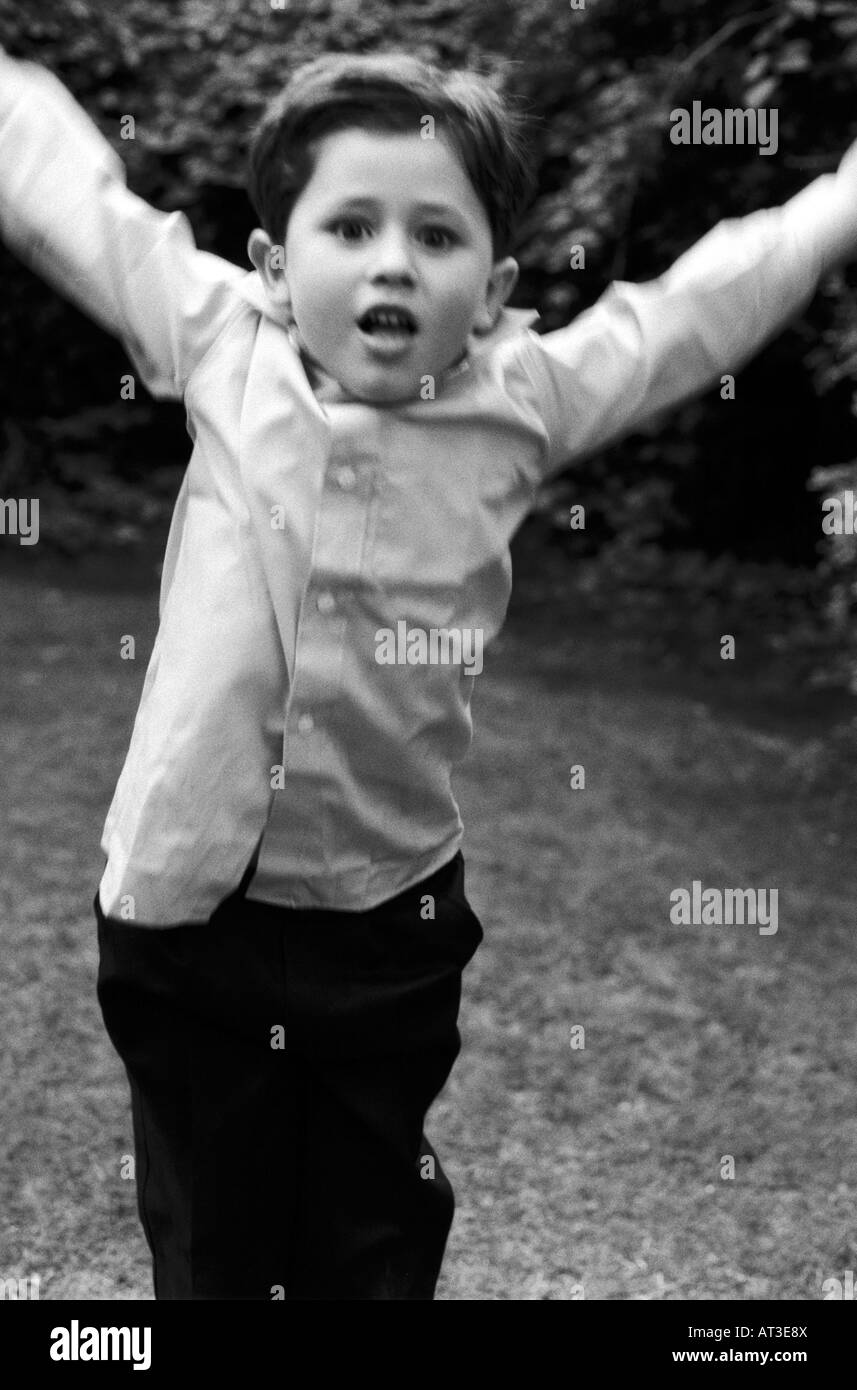 A young boy jumping with his arms raised in the air Stock Photo - Alamy
