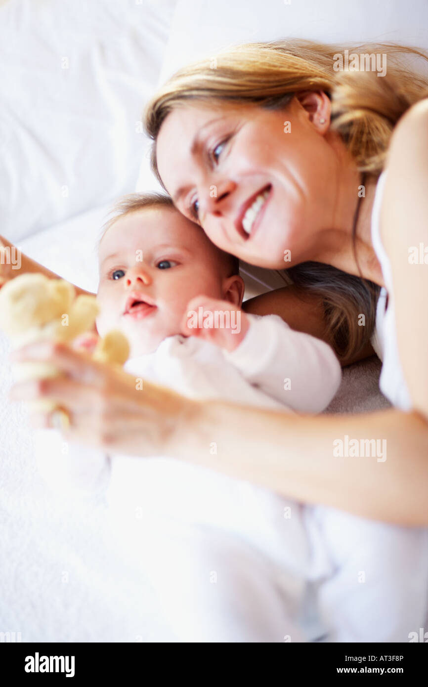 A mother showing her baby a soft teddy bear toy Stock Photo - Alamy