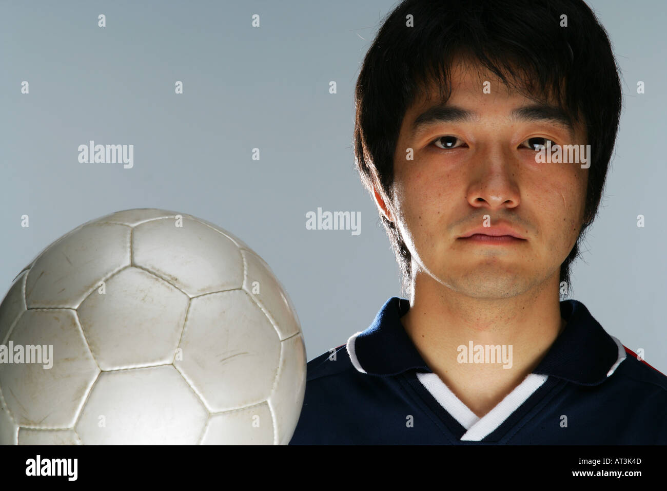 Determined soccer player holding ball Stock Photo