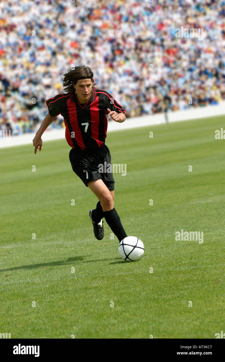Soccer player running with ball Stock Photo