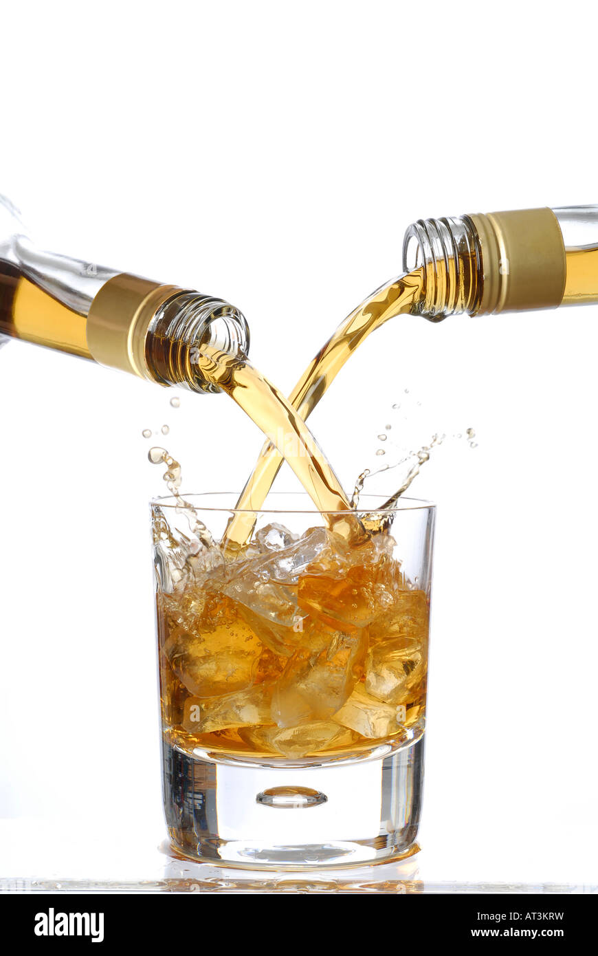 Rum pouring into a single glass from two bottles Stock Photo Alamy