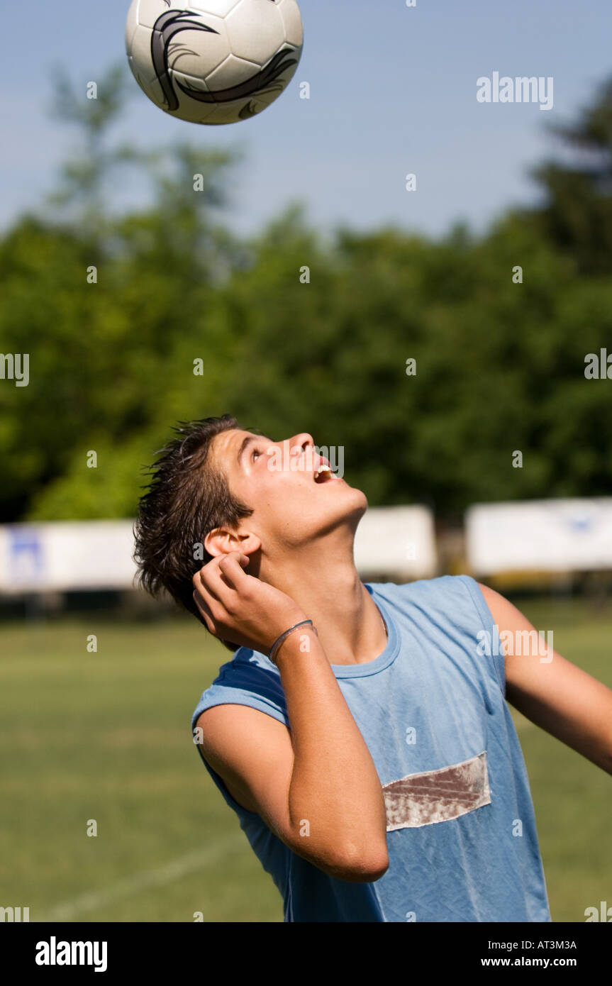 Teenage boy juggling soccer ball with head Stock Photo Alamy