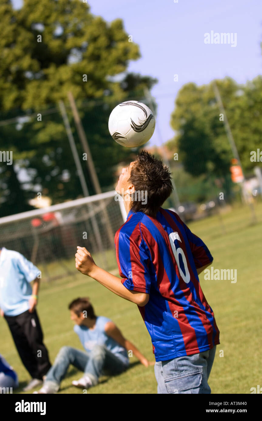 Teenage boy juggling soccer ball with head Stock Photo Alamy