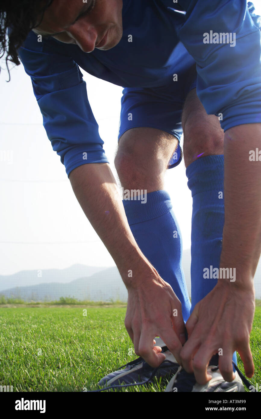 Soccer player tying boot laces Stock Photo