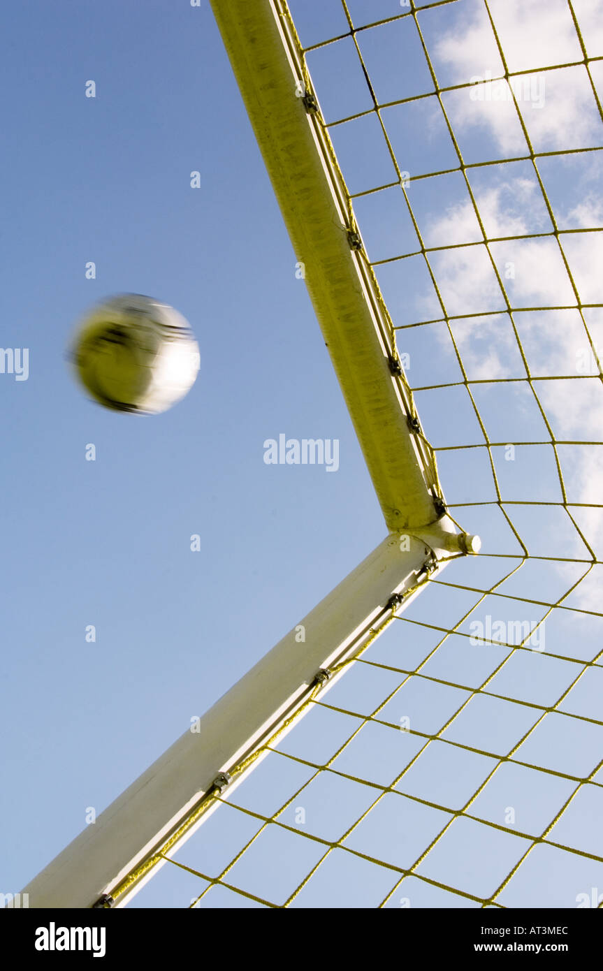 Soccer ball flying into top corner of goal Stock Photo
