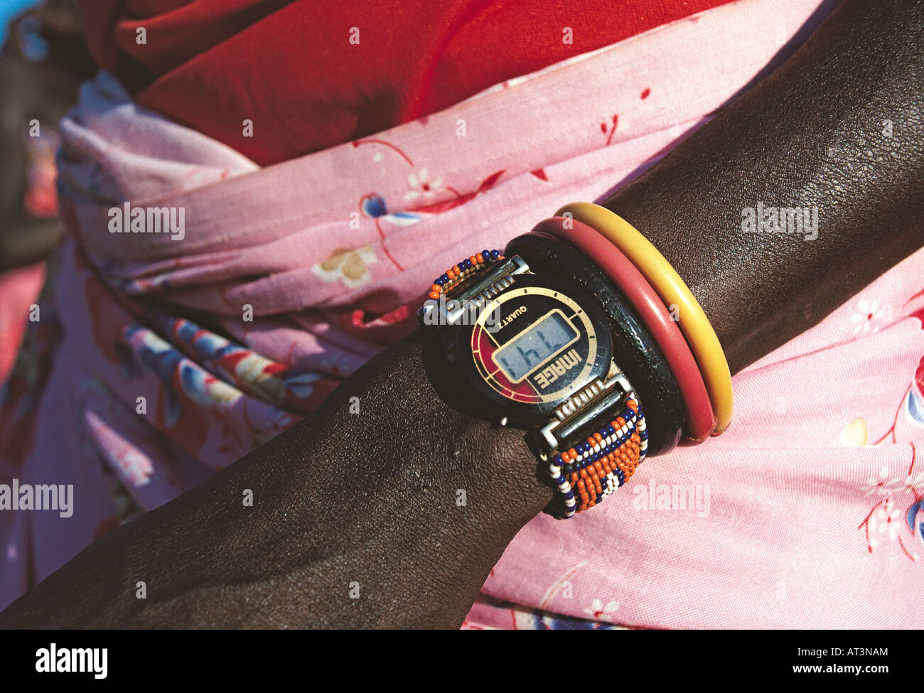Close up of Samburu warrior s arm with two coloured plastic bracelets and a quartz digital watch on a traditional leather strap Stock Photo