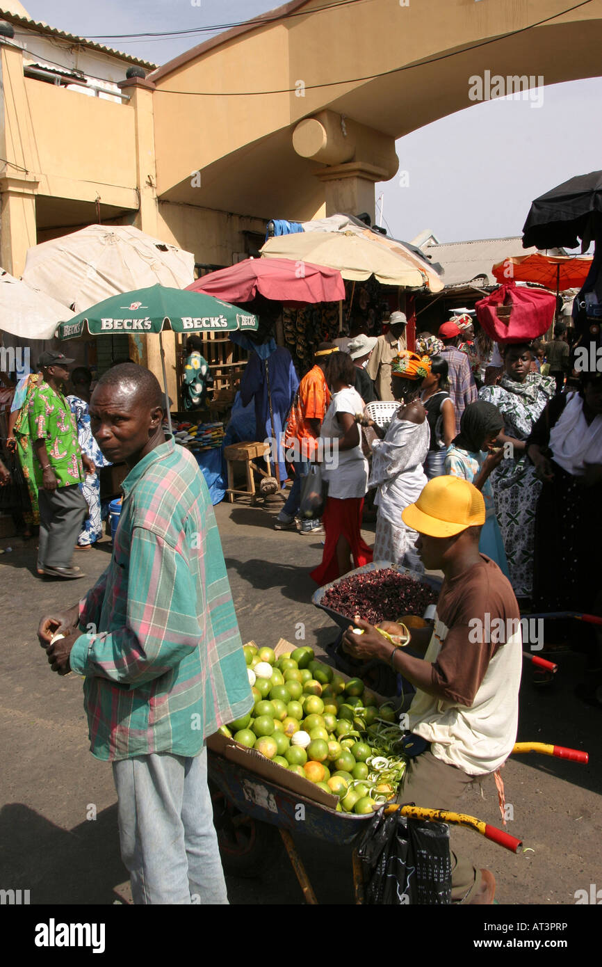 The Gambia Banjul Albert Market man selling oranges from wheelbarrow Stock Photo