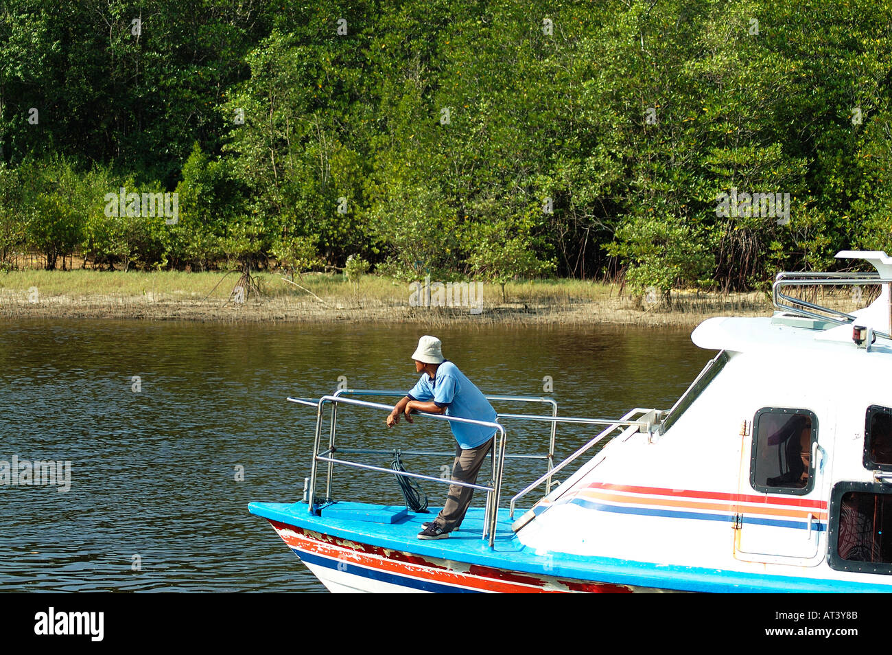 Man in hat looking over speed boat Stock Photo - Alamy