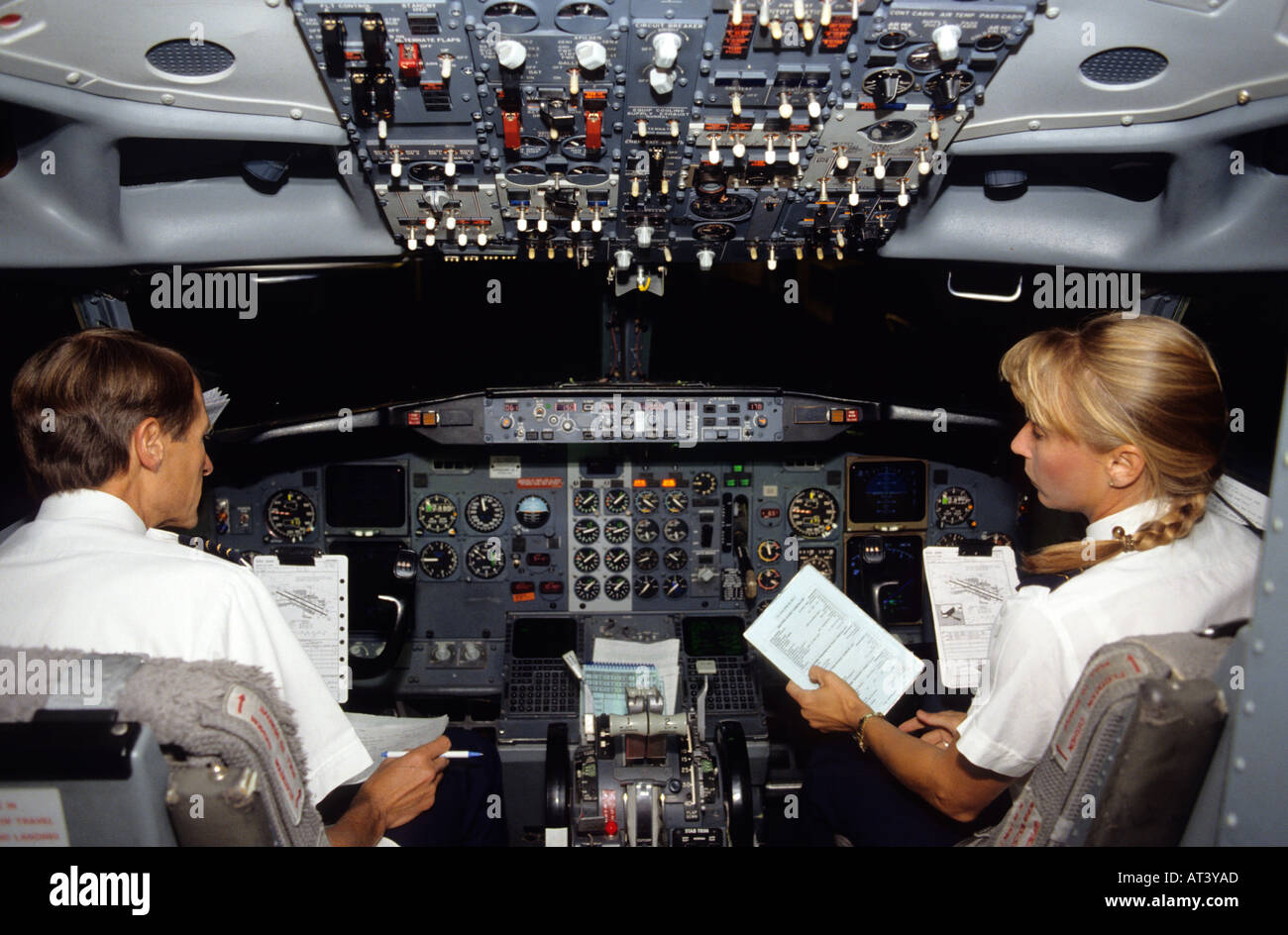 Male pilot and female co-pilot in the cockpit of a Boing 737 commercial airplane. Stock Photo