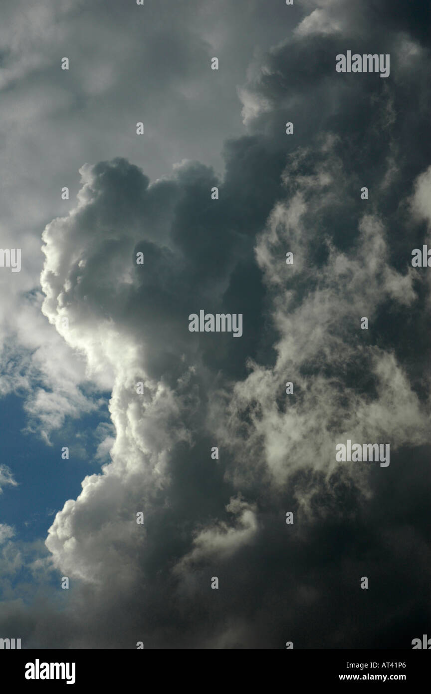 Bright sunlight behind very large dramatic black storm clouds. Suitable for use as background image. Stock Photo