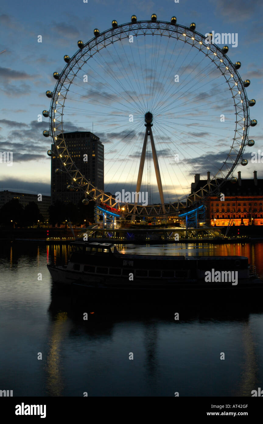 View of London Eye Ferris wheel and River Thames at sunrise seen from opposite bank of the river Stock Photo