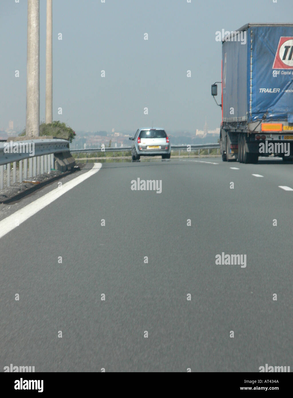car overtaking a truck driving along on a motorway in France Stock Photo