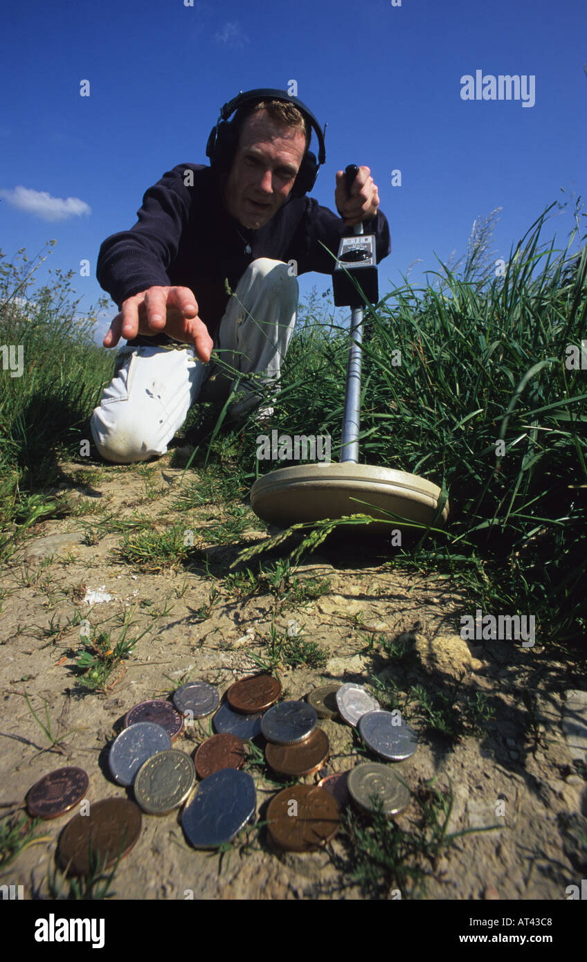 man using metal detector to find horde of coins in field yorkshire uk
