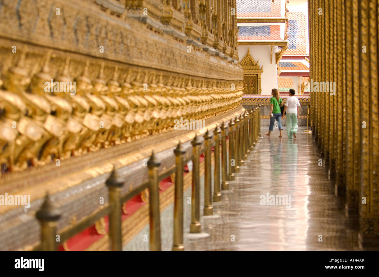 People walking past the 112 Garudas mythical beasts at the grounds of the Grand Palace Bangkok Thailand Stock Photo