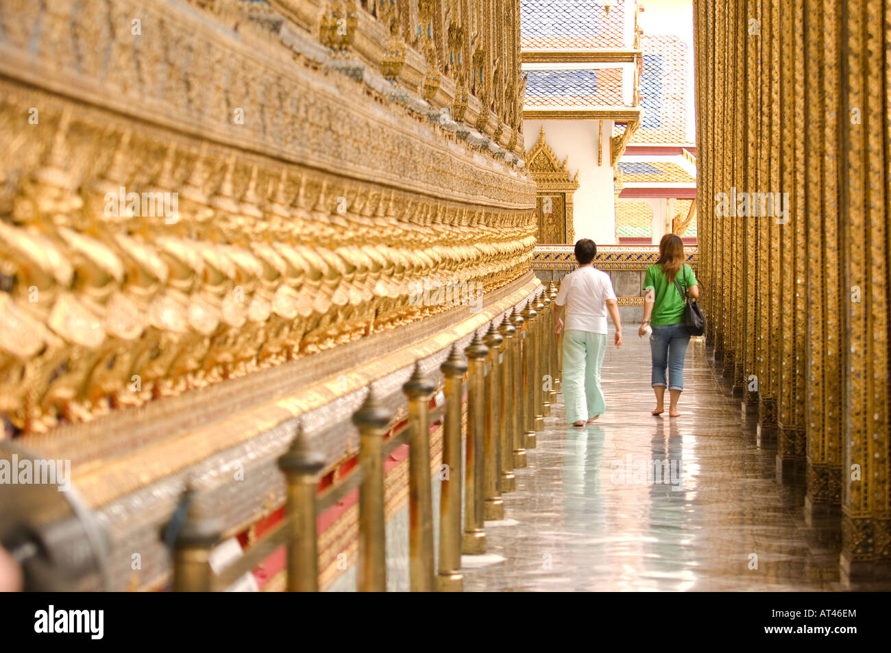 People walking past the 112 Garudas mythical beasts at the grounds of the Grand Palace Bangkok Thailand Stock Photo