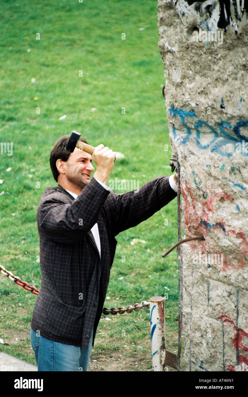 The Fall of the Berlin wall, 1989. A souvenir hunter cuts pieces of the wall. Stock Photo