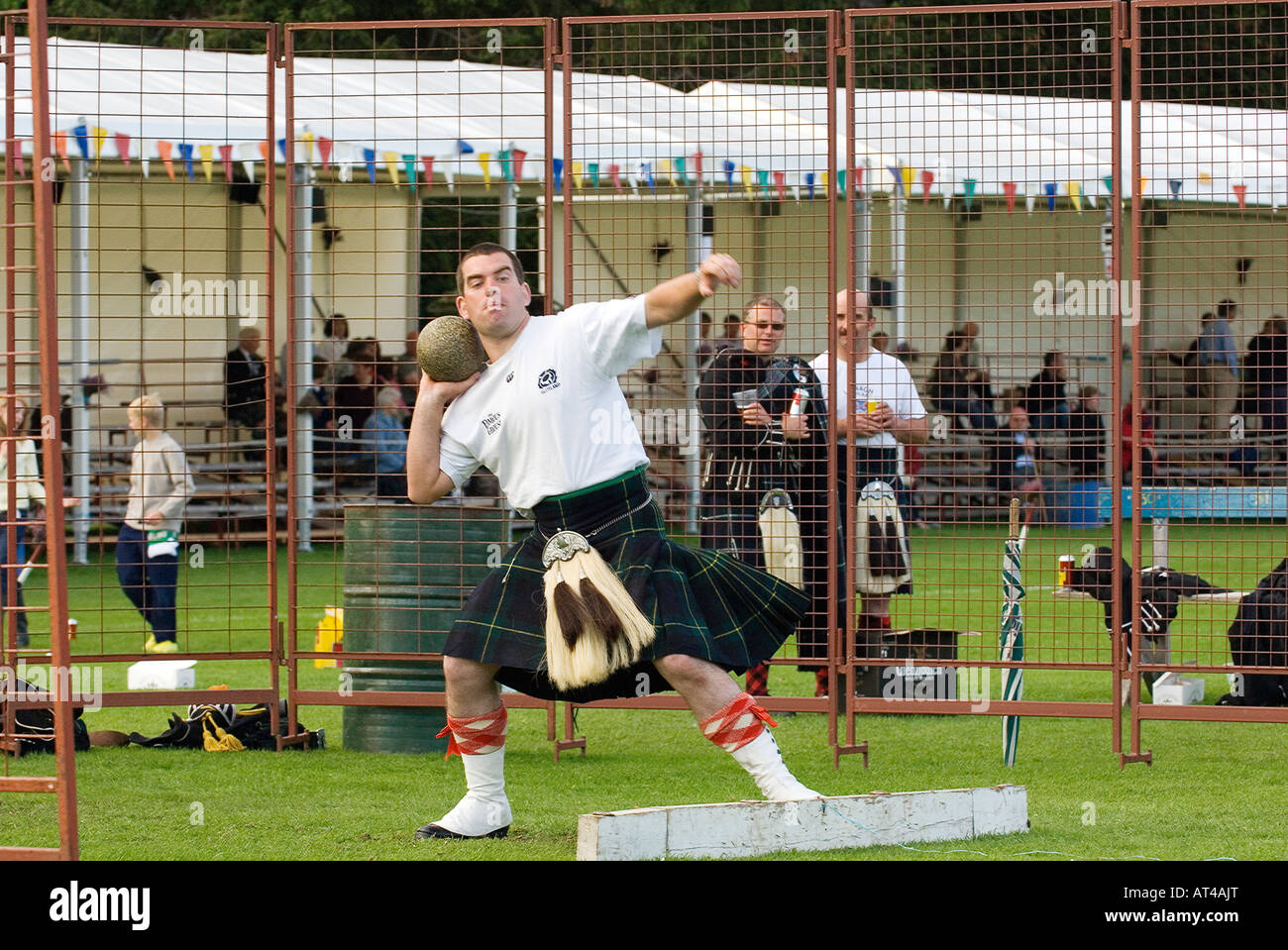 Lonach Highland Games at Strathdon, Grampian, Scotland. Competitor wearing traditional kilt putting the stone Stock Photo