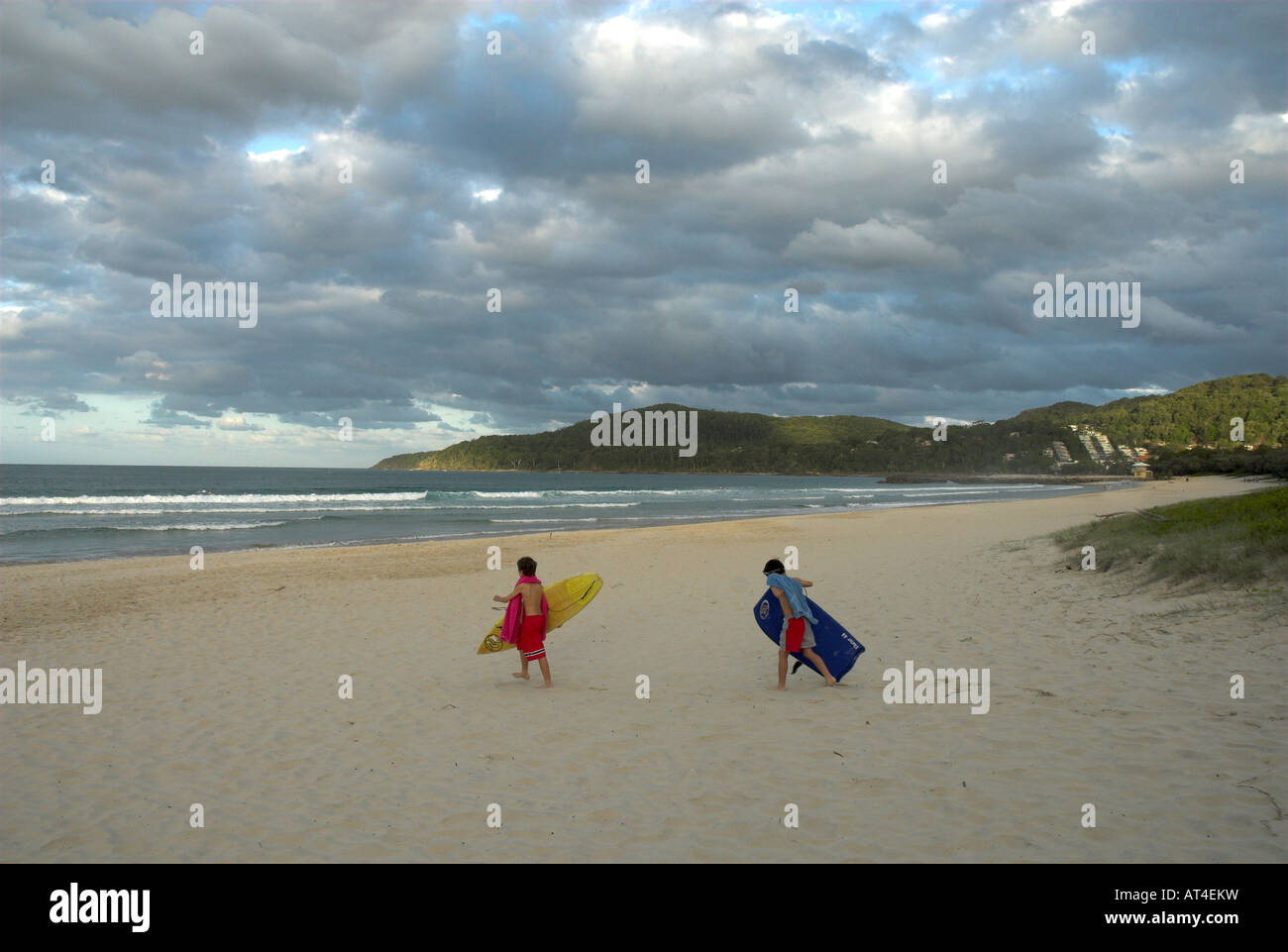 Two boogie boarders heading towards the waves, Noosa Beach, Queensland ...