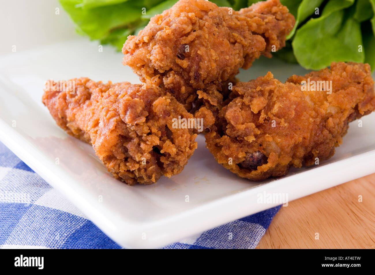 A plate with golden deep fried chicken wings displayed with a range of packaged dips Stock Photo