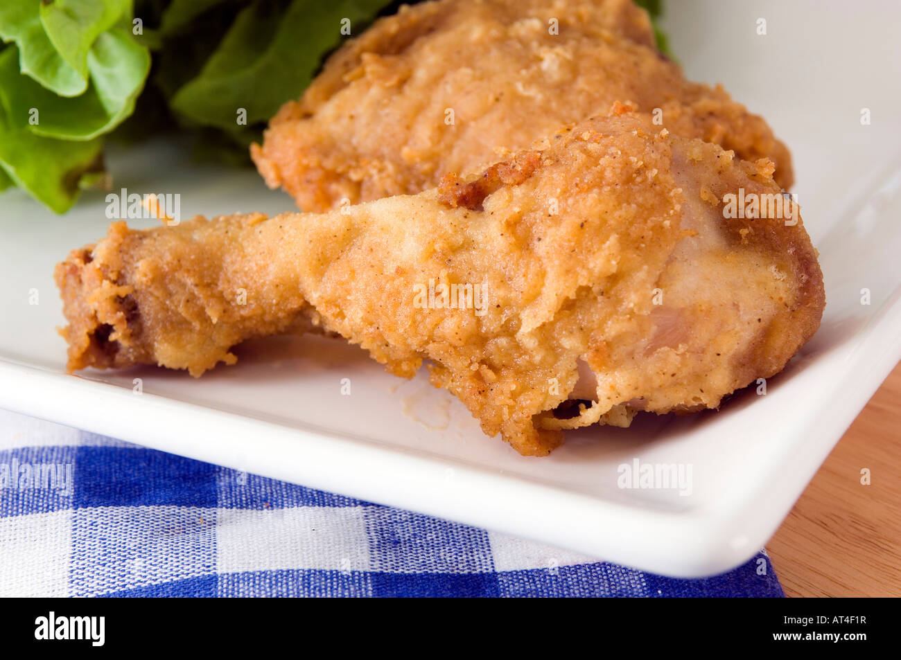 A plate with a golden deep fried chicken leg displayed with a range of packaged dips Stock Photo