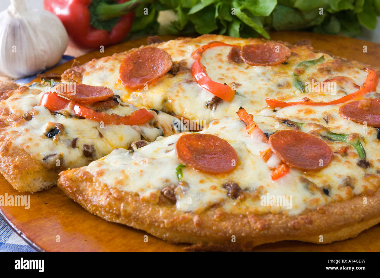 A hot mozzarella & pepperoni Pizza pie presented with fresh produce on