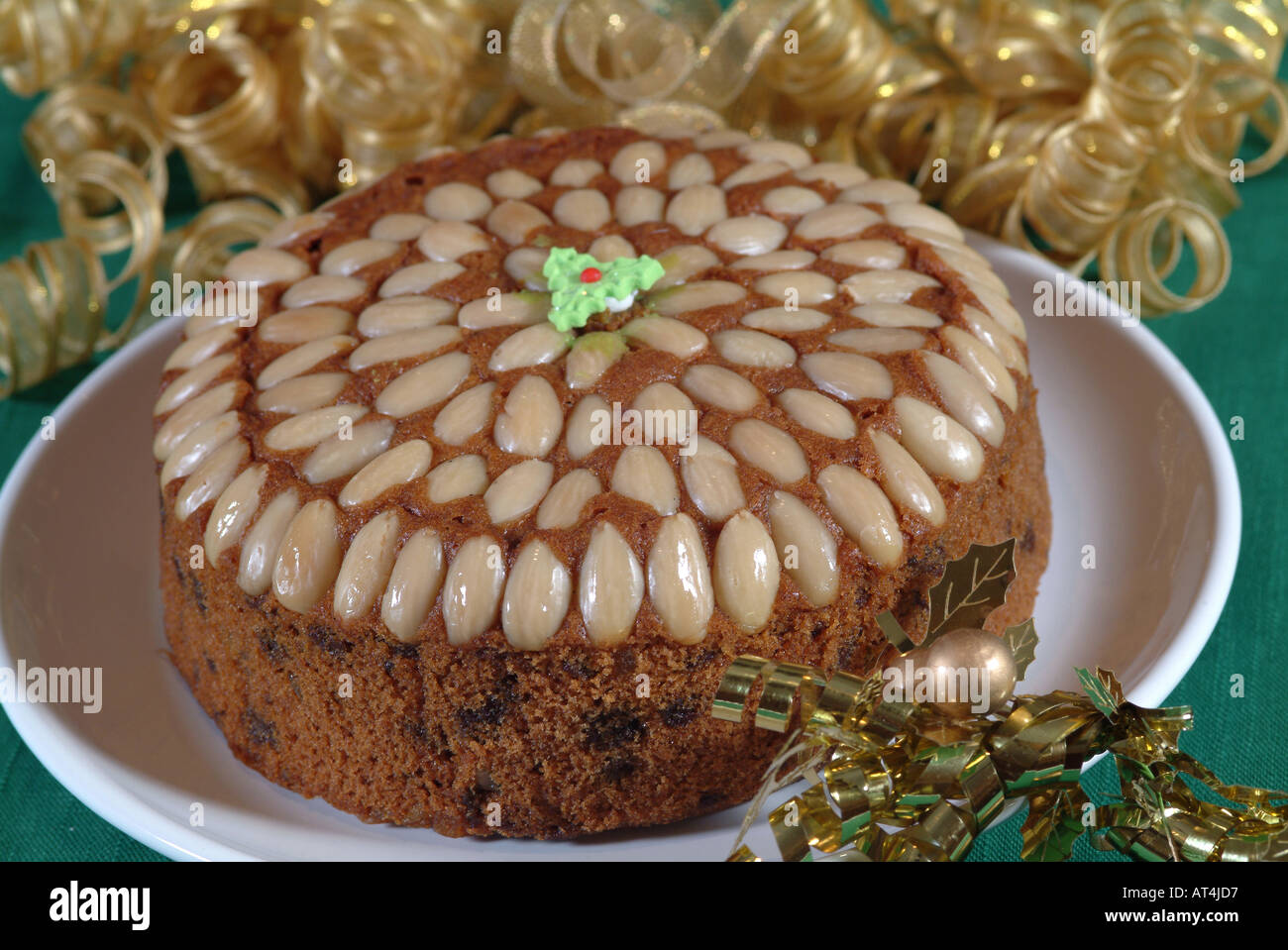 Round Dundee Cake Prepared for Christmas with Holly and Gold Ribbon Stock Photo