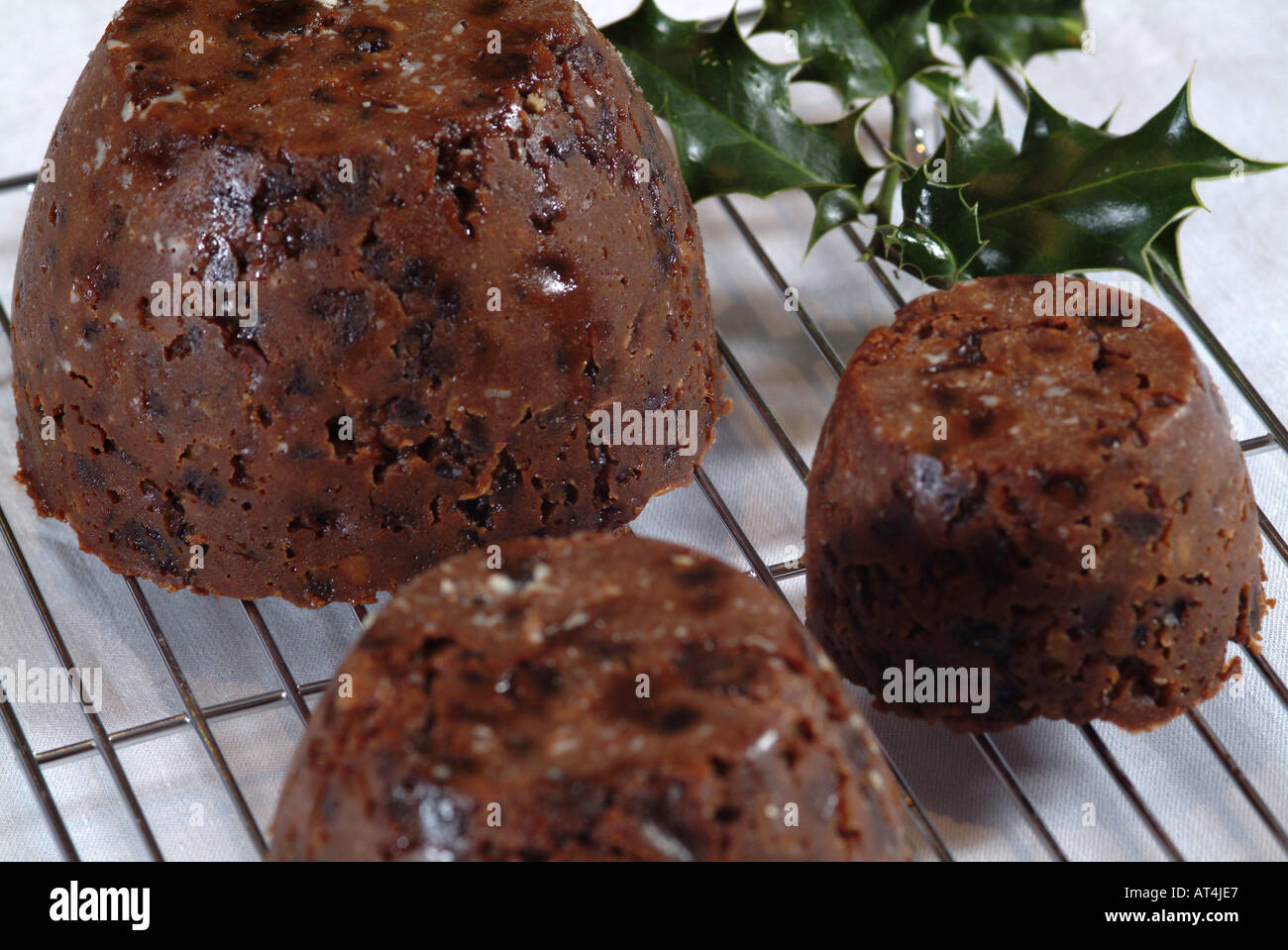 Three Christmas Puddings on Wire Baking Tray Prior to Steaming Stock Photo