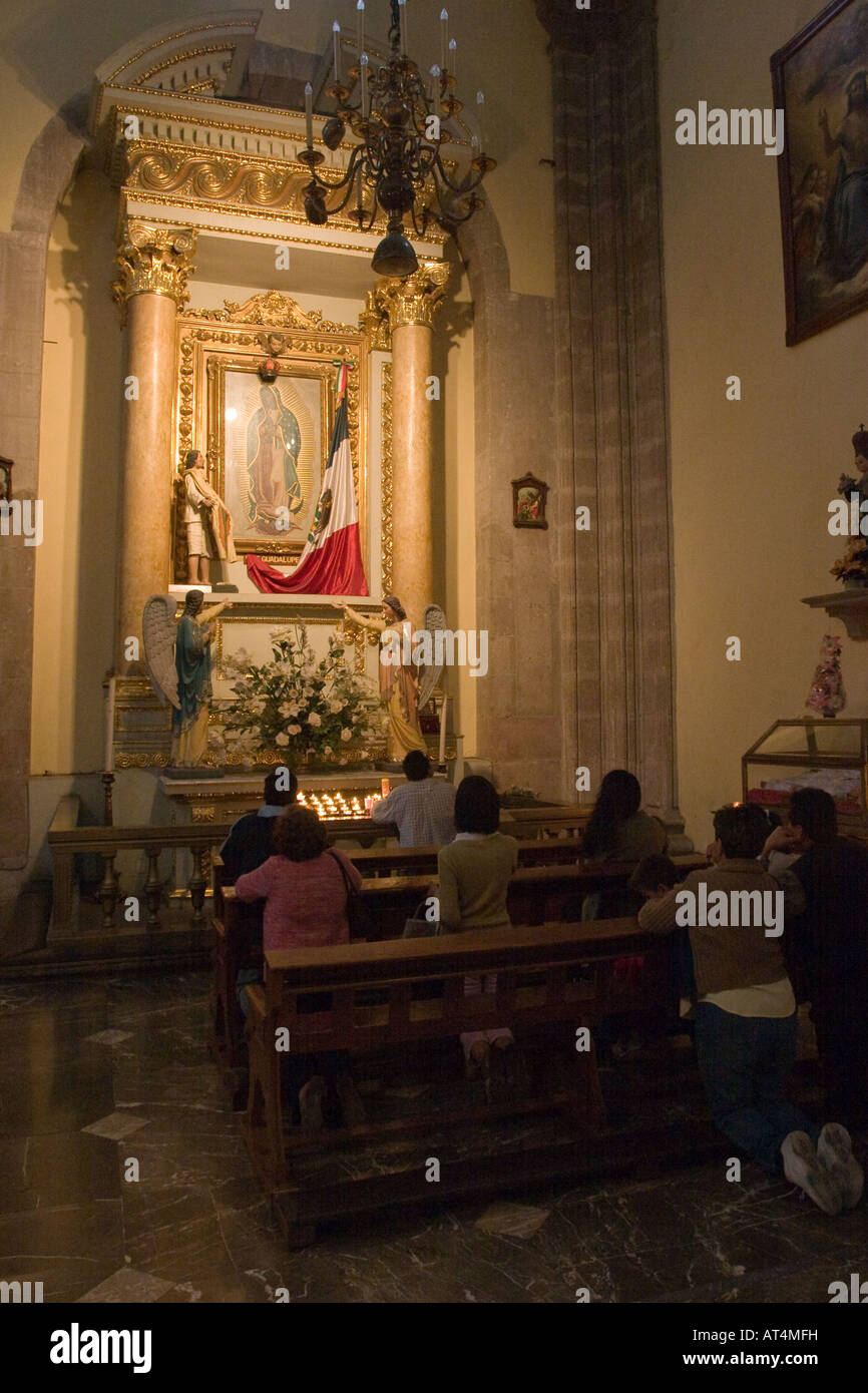 People praying to the virgin inside the Sagrario Metropolitano (Metropolitan Sacristy) in Mexico City, DF, Mexico. Stock Photo
